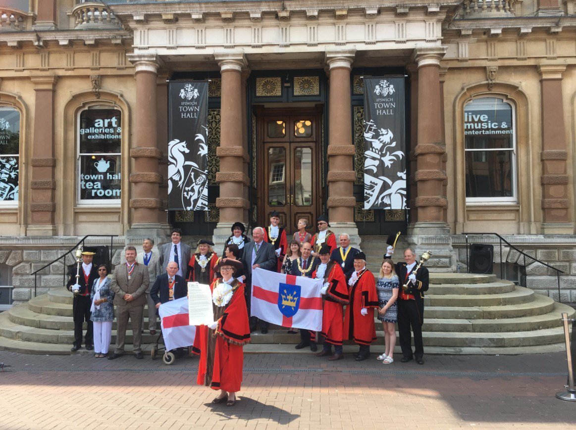Suffolk Mayors holding Suffolk flags on the steps of the Town Hall in Ipswich